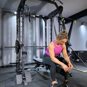 woman sitting on power rack home gym